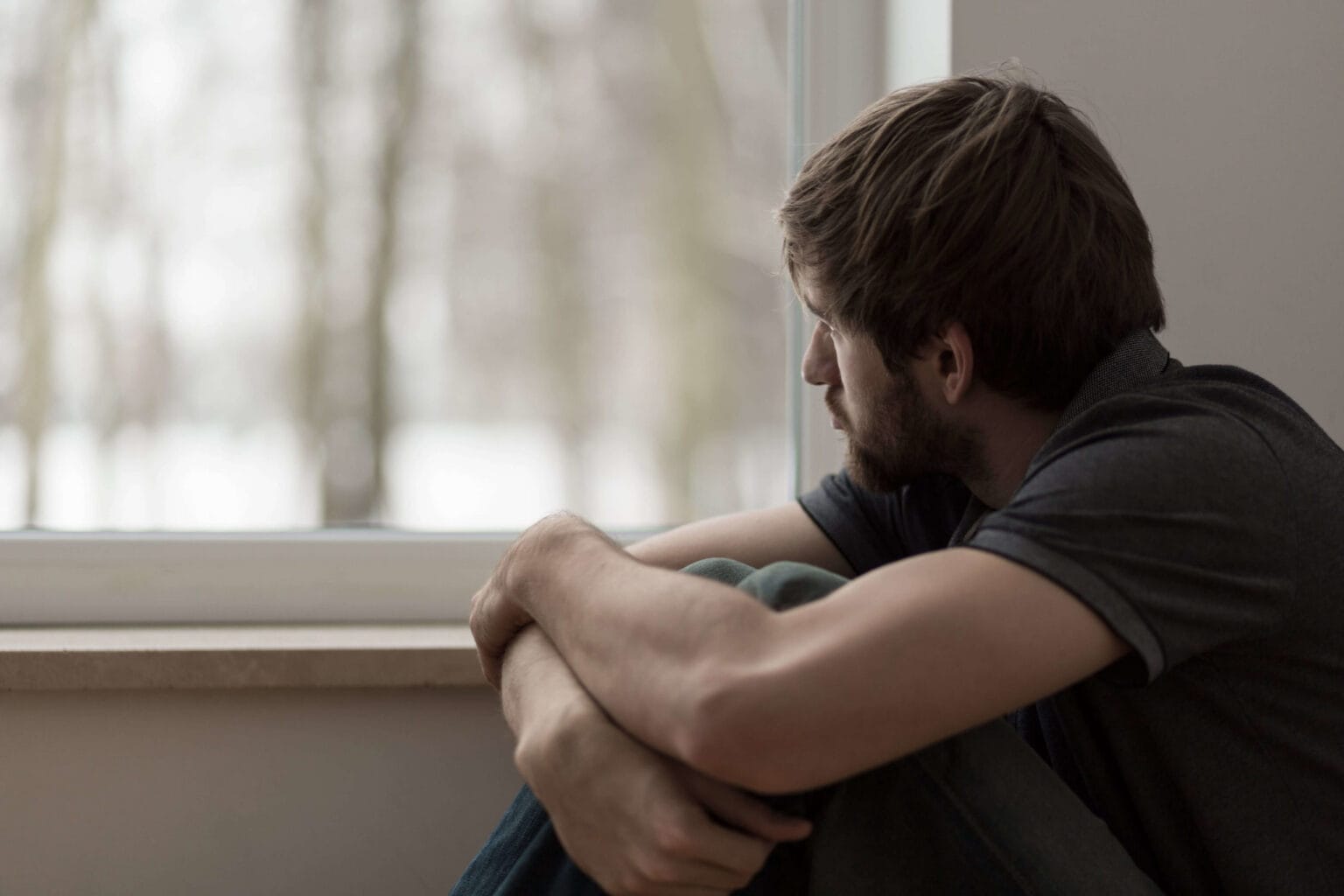 man with high functioning depression staring out a window